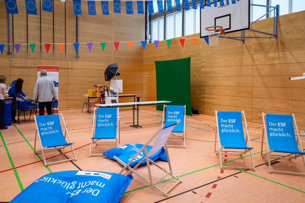 Liegestühle und Sitzsäcke des ESF Thüringen in der Sporthalle, im Hintergrund die Fotobox